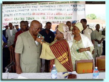 President Kabbah being decorated by Minister of Social Welfare, Gender and Children's Affairs, Mrs. Shirley Gbujama and her deputy Mrs. Memunatu Koroma
