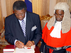 Acting President Justice Edmund Cowan signing the oath